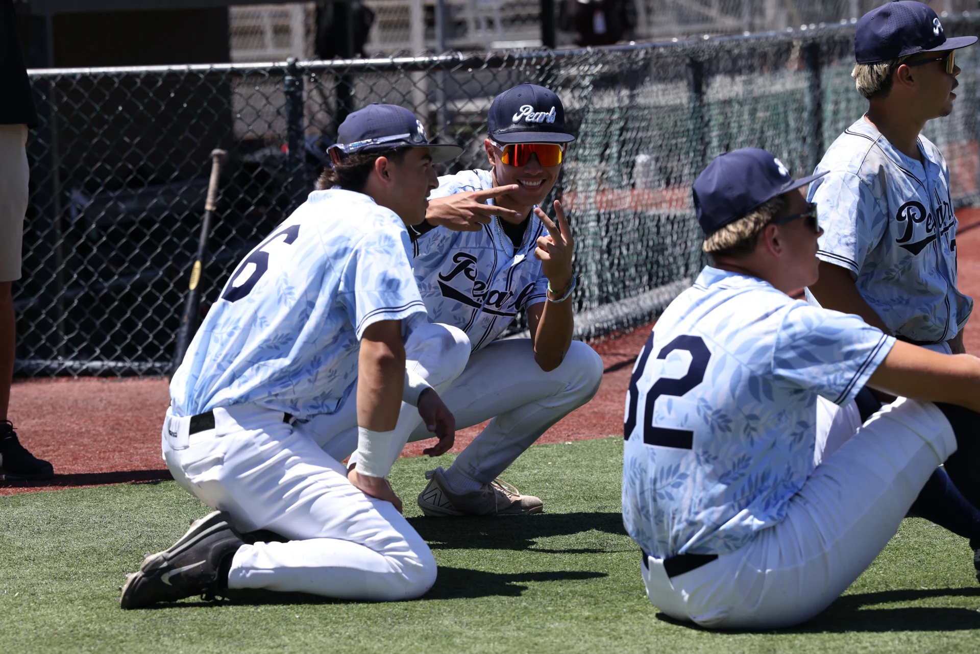 Stockton Pearls teammates together beside the field, with a player flashing a peace sign